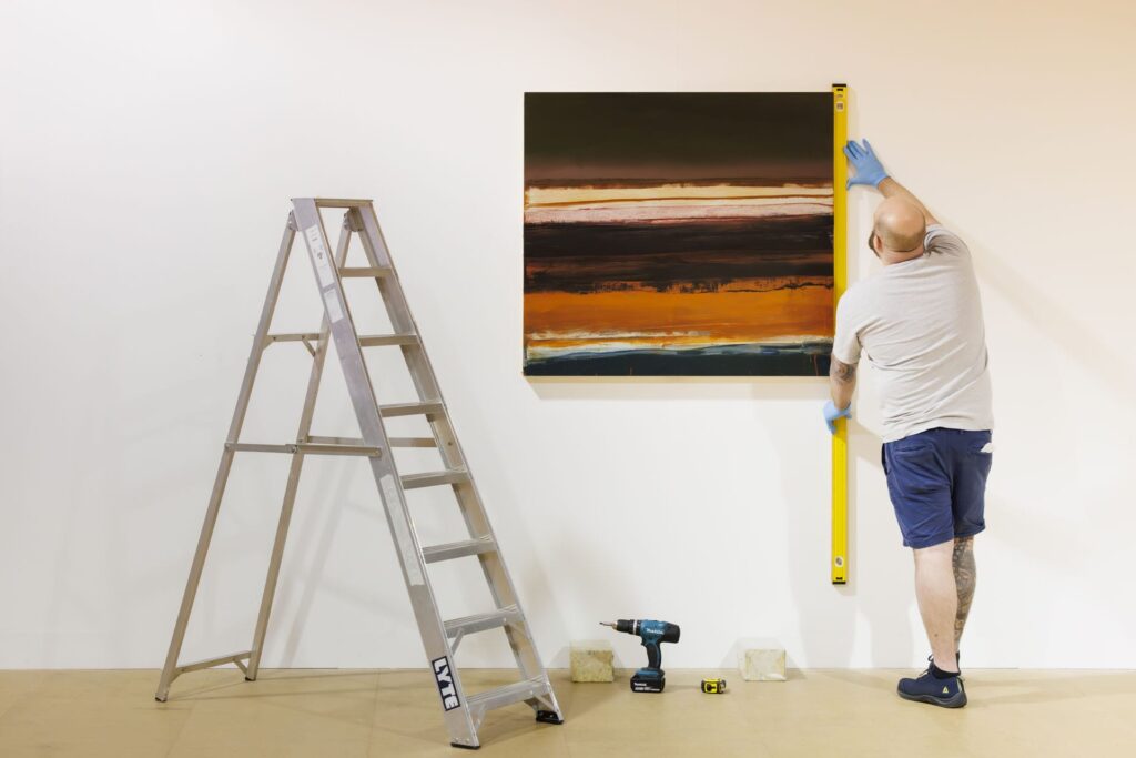 Picture hanging carefull stepladders